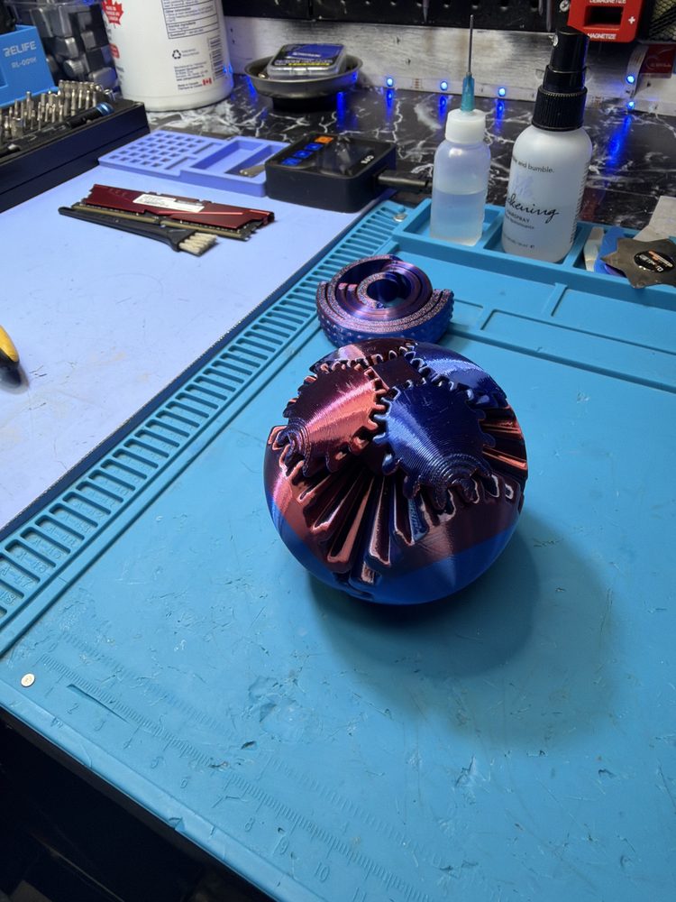 Iridescent purple mechanical gear ball closed into a sphere