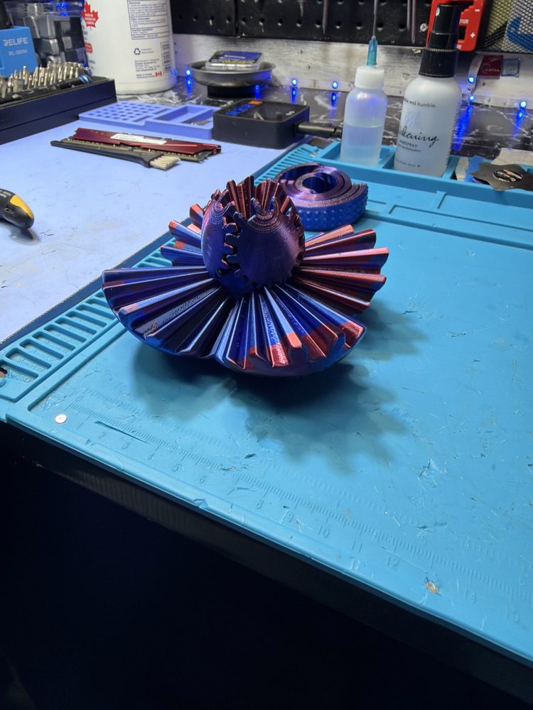 Iridescent purple mechanical gear ball printed open like a flower